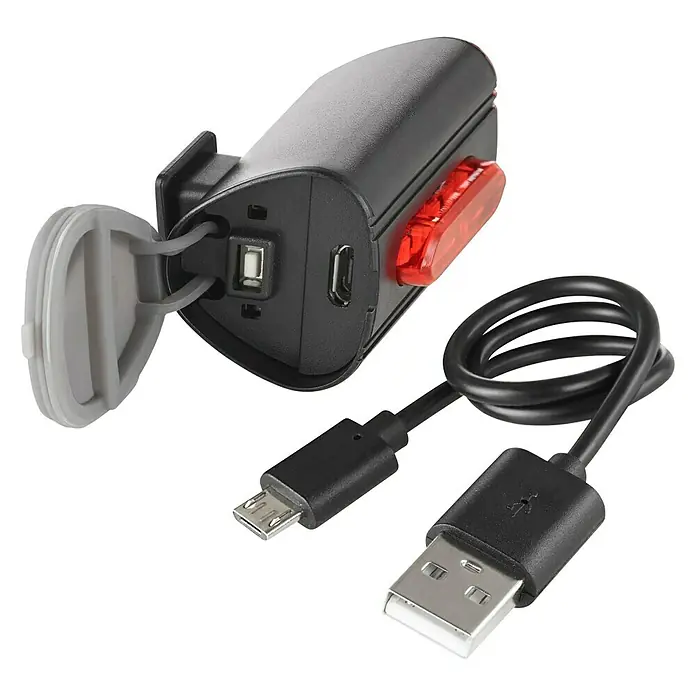 Fischer LED-Akkuleuchten-Set Twin - 5 -tlg., Beleuchtungsstärke: 50 lx, Leuchtdauer: 4 h, Spritzwassergeschützt - Nahaufnahme einer Fahrradrückleuchte und eines USB-Kabels zum Aufladen. Das Licht ist schwarz mit einer roten Linse.