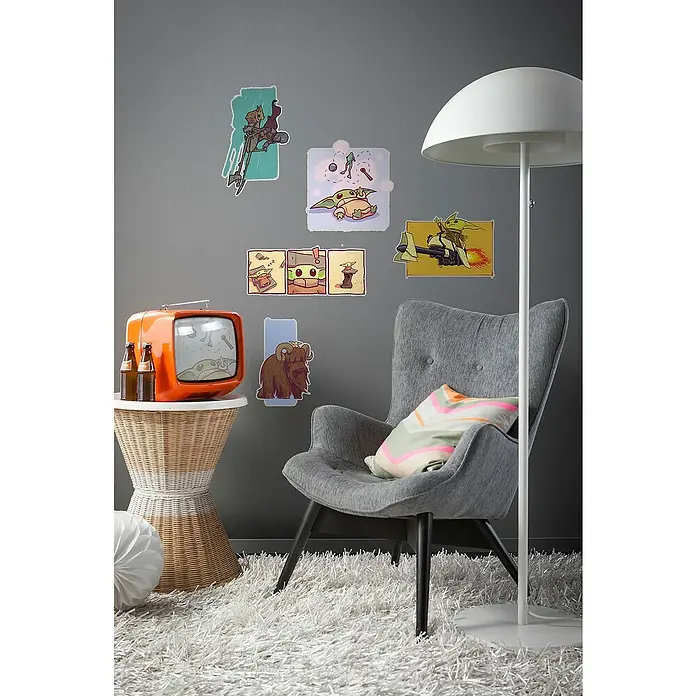Komar Star Wars Wandtattoo Mandalorian Funny Grogu - Bunt, 50 x 70 cm, 5 -tlg. - Gemütliches Wohnzimmer mit Star Wars-Motiven an der Wand, einem Sessel und einem orangefarbenen Fernseher.