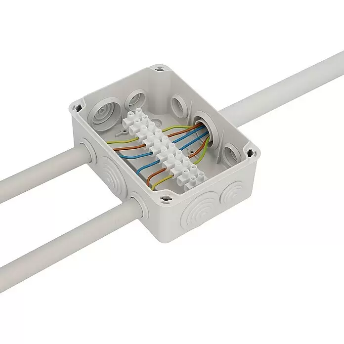 Abzweigdose - 160 x 115 x 70 mm, Aufputz - Weiße Elektroabzweigdose mit internen Klemmenblöcken für bunte Kabel und zwei grauen Rohren, die horizontal hineinführen.