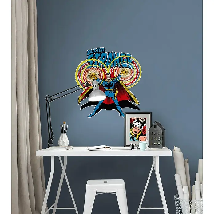 Komar Marvel Wandtattoo Doctor Strange Comic Classic50 x 70 cm - Wanddeko mit Doctor Strange Motiv über einem weißen Schreibtisch mit Lampe, Buch und Deko.