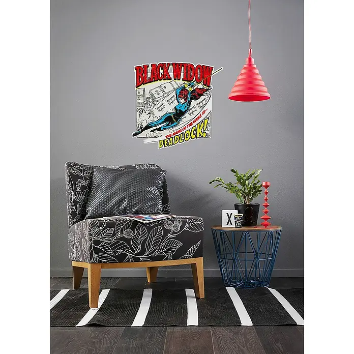 Komar Wandtattoo Black Widow Comic Classic - Blau, Weiß, 50 x 70 cm, 1 -tlg. - Einrichtungsidee mit einem Sessel mit Blätter-Design, einer Beistelltisch und einem Black Widow-Wandsticker.