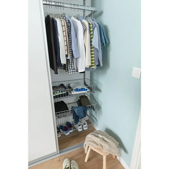 Element System Drahtkorb - 35 x 80 cm, Mit Auszug, Weiß/Aluminium - Ein heller Kleiderschrank mit Kleidung an einer Stange und Metallkörben für gefaltete Kleidung und Schuhe. Ein Hocker steht davor.