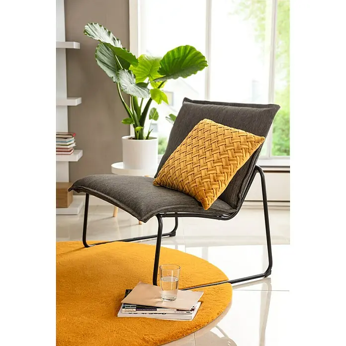 Sunfun Sarah Garten-Loungesessel - Anthrazit, B x T x H: 87 x 68 x 76 cm - Ein grauer Sessel mit einem senfgelben Kissen und einem runden Teppich darunter, der einen modernen und komfortablen Wohnbereich schafft.