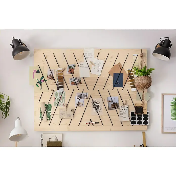 Tween Light Tischleuchte Wood - 40 W, L x B x H: 21 x 15,5 x 52 cm, E27 - Eine hölzerne Notiztafel mit diagonalen Schnüren hält Zettel, Fotos und eine Pflanze an einer weißen Wand, beleuchtet von zwei Lampen.
