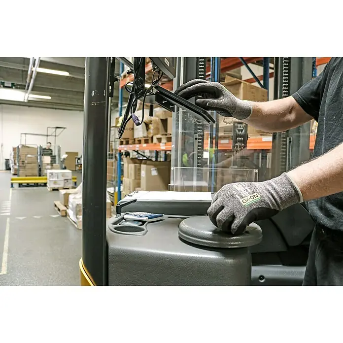 OX-ON Arbeitshandschuhe Recycle Supreme 16603 - Grau/Schwarz, 11 - Ein Bediener mit grauen OX-ON Arbeitshandschuhen, der einen Gabelstapler fährt. Fokus auf die schützenden Handschuhe während der Arbeit.