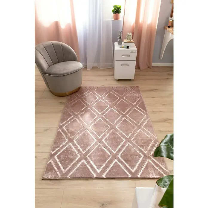 Kayoom Kurzflorteppich Monroe IIIRosa, 170 x 120 cm, 100 % Polyester - Ein rosafarbener Teppich mit einem Rautenmuster liegt im Raum, ergänzt den Sessel und das minimalistische Dekor.