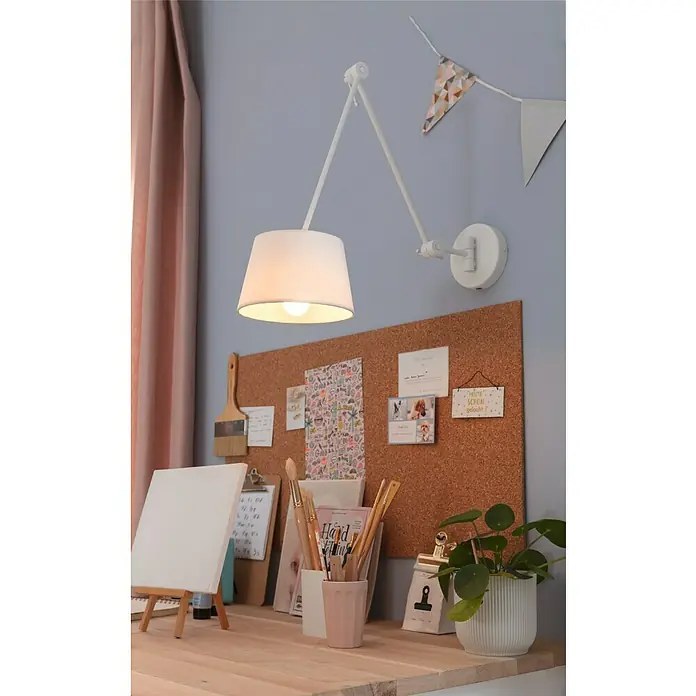 SCHÖNER WOHNEN-Farbe Wandfarbe Designfarbe - Klares Eisblau, Matt, 2,5 l, Konservierungsmittelfrei - Eine verstellbare, weiße Schreibtischlampe mit einem Lampenschirm beleuchtet einen Schreibtisch mit Kunstbedarf und Dekorationen.