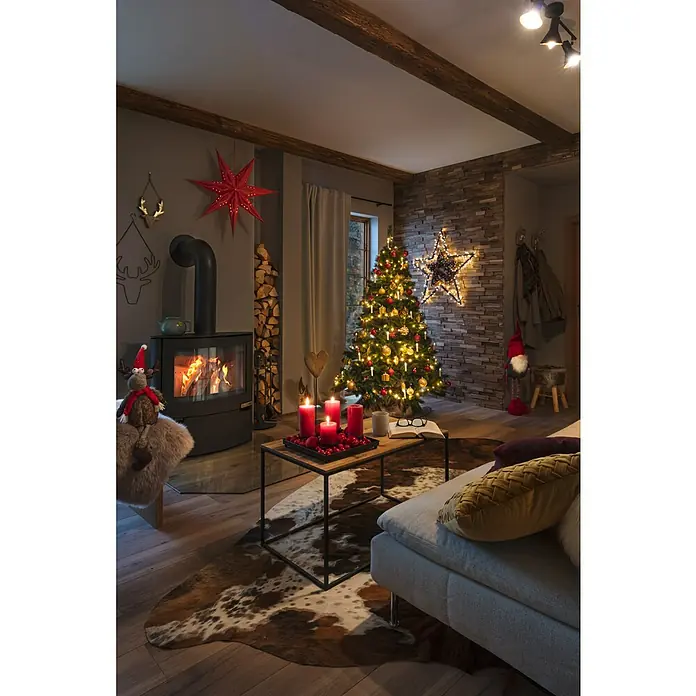 Aduro Kaminofen 15 - 6,5 kW, Raumheizvermögen: 350 m³, Material Verkleidung: Stahl, Schwarz - Gemütliches Wohnzimmer mit Kamin und Weihnachtsbaum. Rote Kerzen auf dem Tisch sorgen für festliche Stimmung im Raum mit Kuhfellteppich.