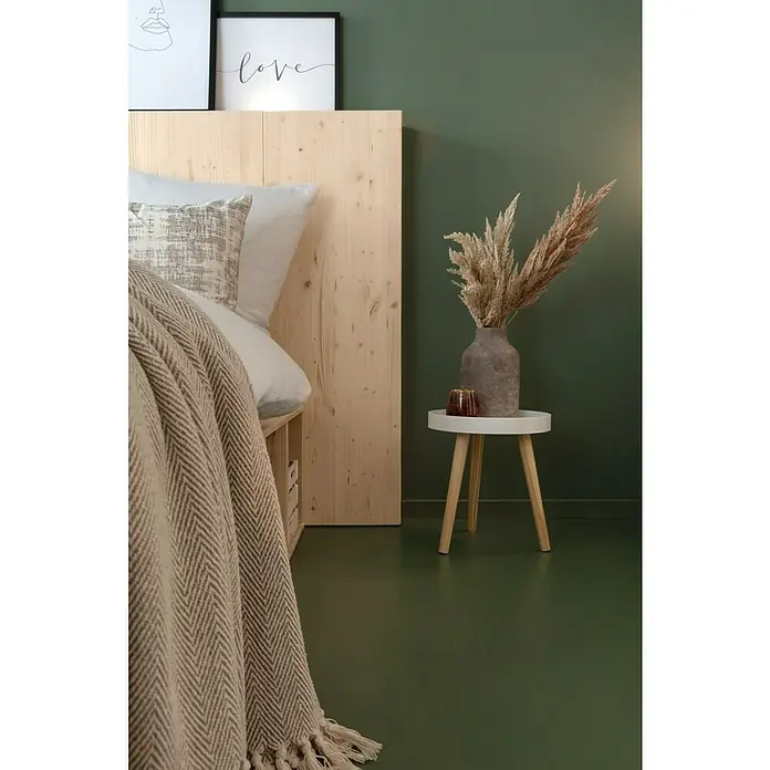 SCHÖNER WOHNEN-Farbe Wandfarbe Designfarbe - Ausgeglichenes Piniengrün, Matt, 2,5 l, Konservierungsmittelfrei - Ein Schlafzimmer mit einem hellen Holz Kopfteil, einem beigen Tagesdecke und einem kleinen Tisch mit Vase.