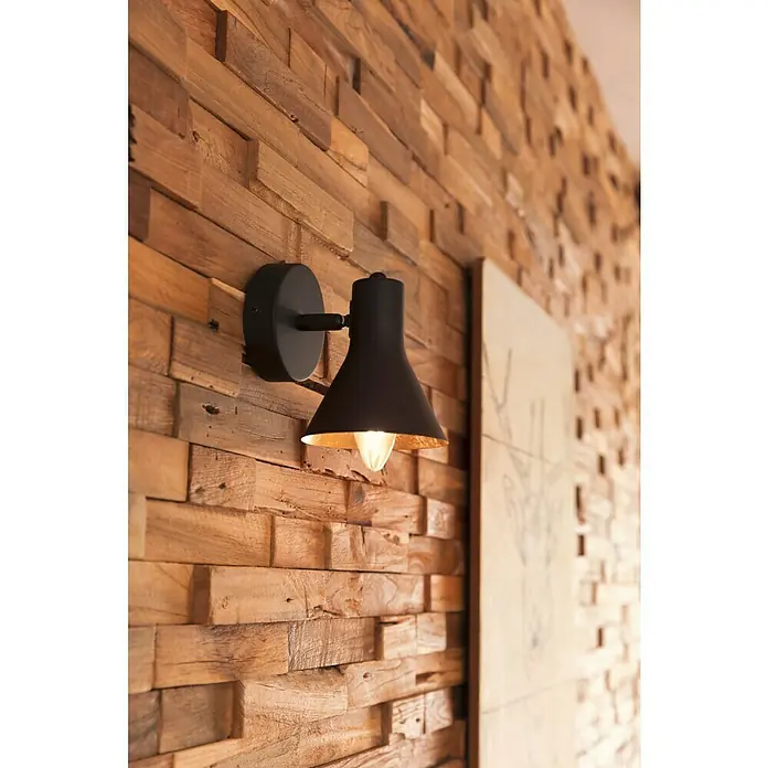 Reality Leuchten Nina Deckenstrahler - 40 W, Gold, Schwarz, E14, 1 Stk. - Nahaufnahme einer modernen schwarzen Wandleuchte mit goldener Innenseite an einer Holzwand, die ein warmes, einladendes Licht ausstrahlt.
