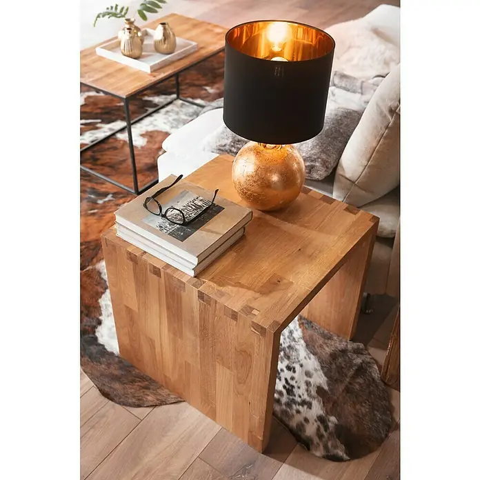 Exclusivholz Aspen Hocker - Eiche, 41,8 x 43 x 43 cm - Nahaufnahme eines quadratischen Beistelltisches aus Eiche mit einem schwarzen Lampenschirm und einer goldenen Lampenbasis.
