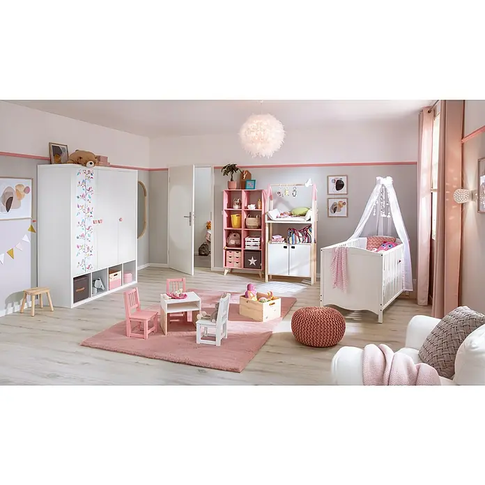 Fellteppich Happy - Rosa, 150 x 80 cm, 100 % Polyester (Flor) - Ein helles Kinderzimmer mit einem weißen Kinderbett, einem Kleiderschrank und einem Wickeltisch. Der Raum ist mit rosa Akzenten versehen.