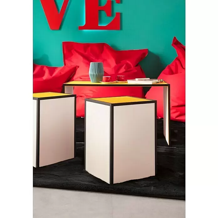 LOGOCLIC Winkelleiste Schwarz - 275 cm x 20 mm x 20 mm - Moderner gelb-schwarzer Konsolentisch mit zwei passenden kubischen Beistelltischen in einer bunten Lounge mit roten Sitzsäcken und türkiser Wand.
