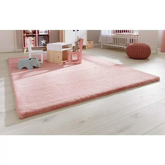 Fellteppich Happy - Rosa, 170 x 120 cm, 100 % Polyester (Flor) - Ein hellrosa Teppich liegt in einem hellen Kinderzimmer mit einem grauen Elefanten, einem kleinen Tisch und einem Stuhl.