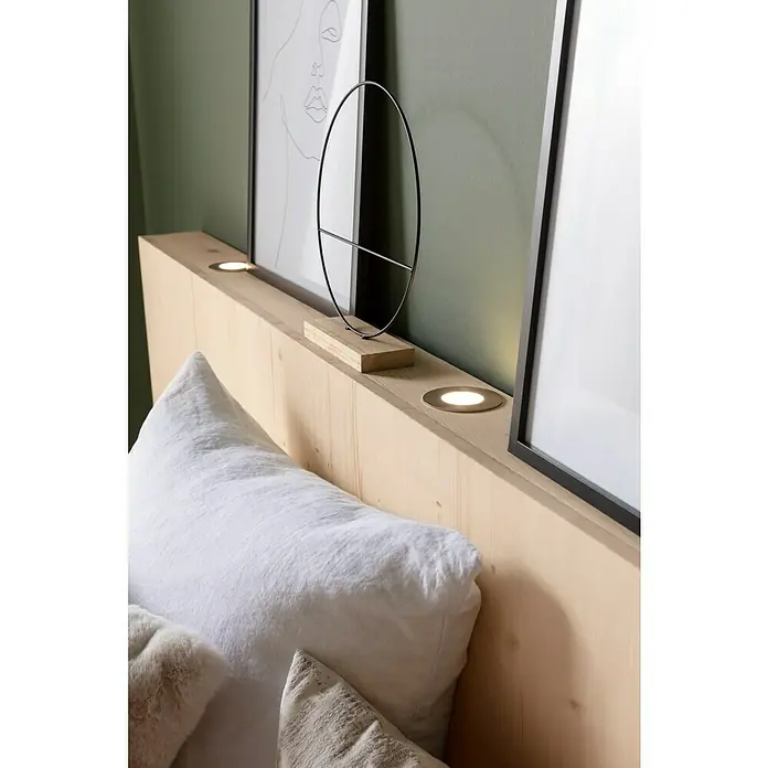 Tween Light LED-Einbauleuchten-Set - 9 W, Nickel matt, Warmweiß - Nahaufnahme eines hellen Holzbettkopfteils mit zwei eingelassenen Lichtern und einem dekorativen, ovalen Metallakzentstück.