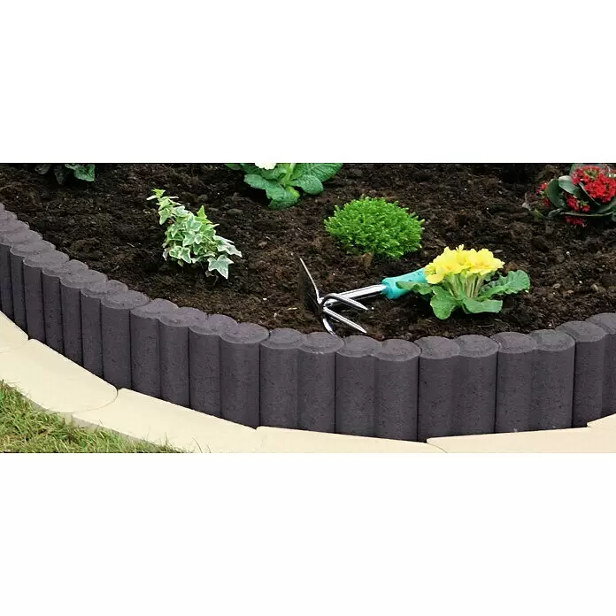 Christoph Palisaden-Randstein - Anthrazit, 9 x 6 x 15 cm, Beton - Dunkelgraue, gewellte Beeteinfassung trennt ein bepflanztes Beet von einem helleren Weg.