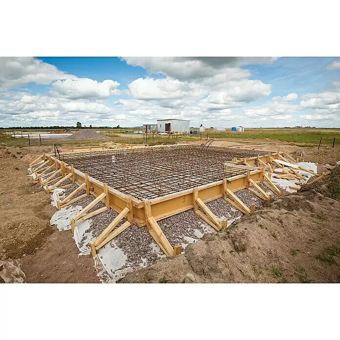 Baudiele - 300 x 28 x 4,5 cm, Fichte - Hausfundament im Bau mit Holzschalung, Stahlbewehrung und Kies, bereit für den Beton auf einer Baustelle.