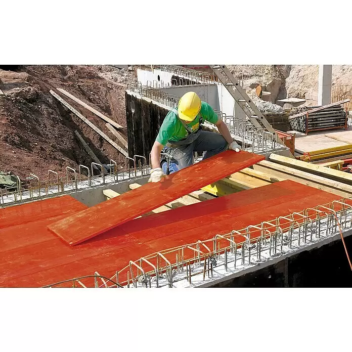 3-Schicht-Schaltafel - 200 x 50 x 2,1 cm, Fichte, Rot - Bauarbeiter montiert rote Schalungsplatten für Beton auf einer Baustelle.