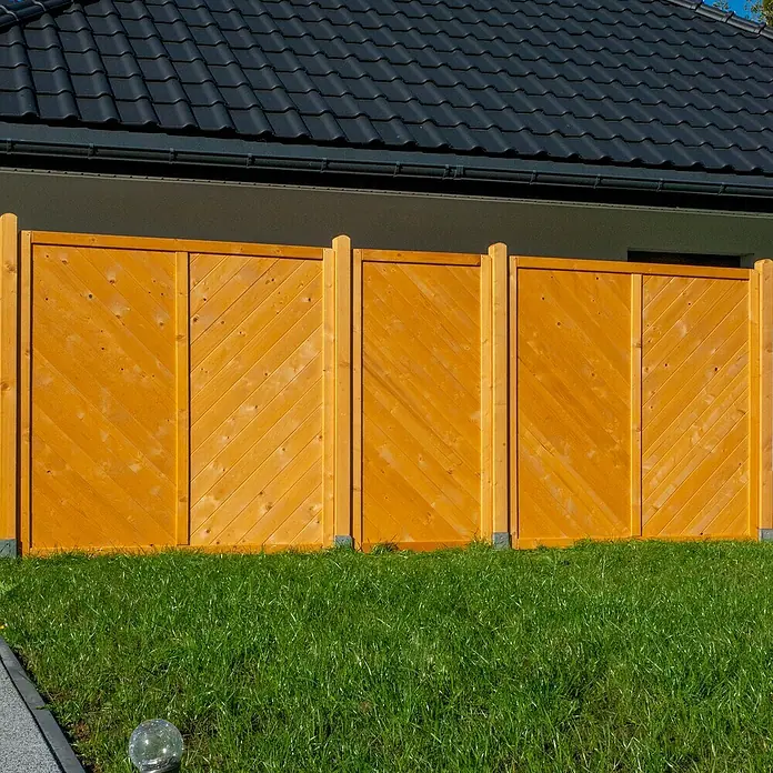 Sichtschutzelement Regensburg - 180 x 180 cm, Honig - Holzzaun in warmem Honigton vor einem grünen Rasen, der Privatsphäre und Ästhetik im Garten vereint. Solider Sichtschutz mit modernem Design.