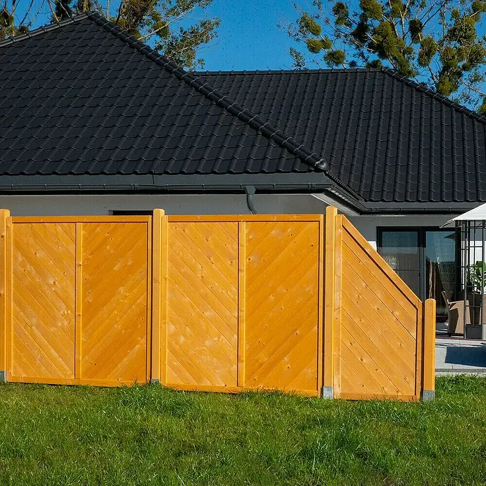 Sichtschutzelement Regensburg - 90 x 90/180 cm, Honig - Detailansicht eines Holzgartenzauns mit diagonaler Bretterstruktur, der Privatsphäre und Ästhetik vereint. Er harmoniert mit Haus und Garten.