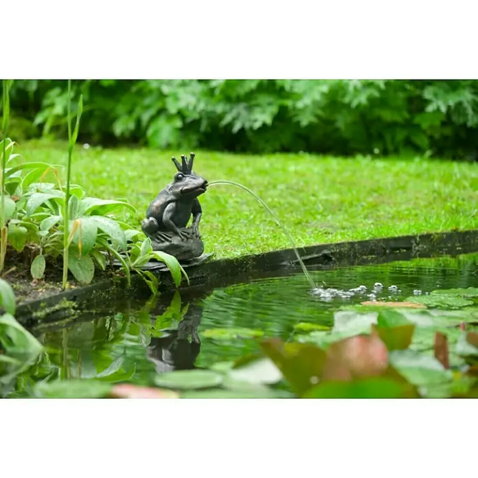 Ubbink Wasserspeier Froschkönigin - 20 x 19 x 27 cm - Detailaufnahme eines Froschbrunnen im Garten, der Wasser in einen Teich speit, umgeben von grüner Vegetation.