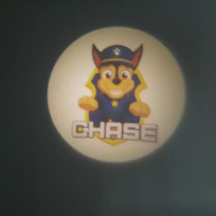 Niermann Taschenlampe Projektor Paw Patrol - Blau, Batteriebetrieben, Kunststoff - Projiziertes Bild von Chase aus Paw Patrol in Polizeiuniform, mit gelbem Schild und seinem Namen.