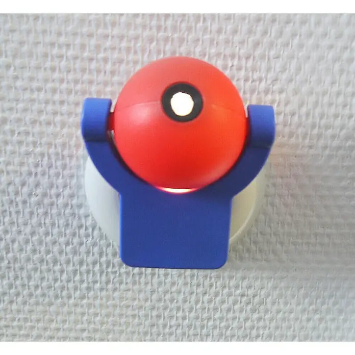 Niermann LED-Nachtlicht Paw Patrol - 1-fach, Netzstecker, Rot/Blau, L x B x H: 90 x 80 x 70 mm - Nahaufnahme einer roten Nachttischlampe mit blauem Sockel auf einer weißen Oberfläche. Die Lampe strahlt warmes Licht aus einem runden Loch.
