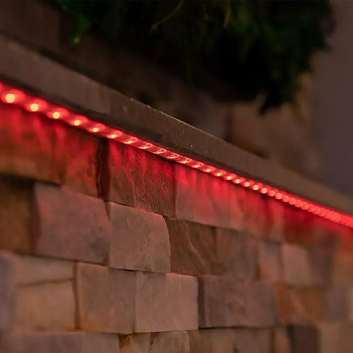 MegaLight LED-Stripes - Länge: 5 m, RGB, 250 lm - Ein dekoratives Bild einer Mauer, die mit einer leuchtenden roten LED-Lichterkette geschmückt ist und eine stimmungsvolle Atmosphäre schafft.