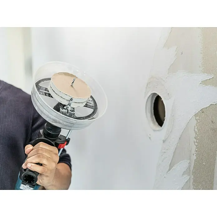 Craftomat Lochsäge Verstellbar - Verstellbar - Nahaufnahme eines Handwerkers, der mit einem Werkzeug ein Loch in eine Wand bohrt, vermutlich für eine Installation.