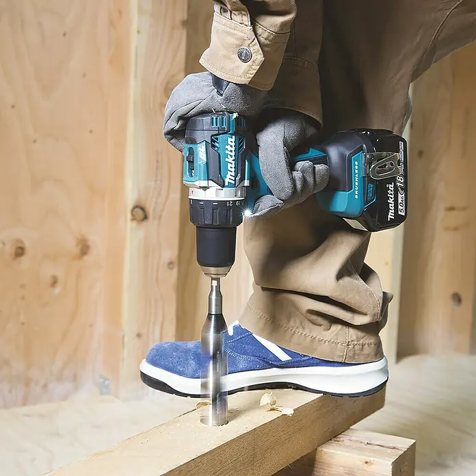 Makita LXT 18V Akku-Bohrschrauber DDF484Z + Artikelnr. 33855482 hinzufügen* - 18 V, Ohne Akku, 54 Nm - Nahaufnahme einer Makita Akku-Bohrmaschine beim Bohren eines Lochs in ein Holzbrett. Ideal für Profi-Handwerker und Heimwerker.