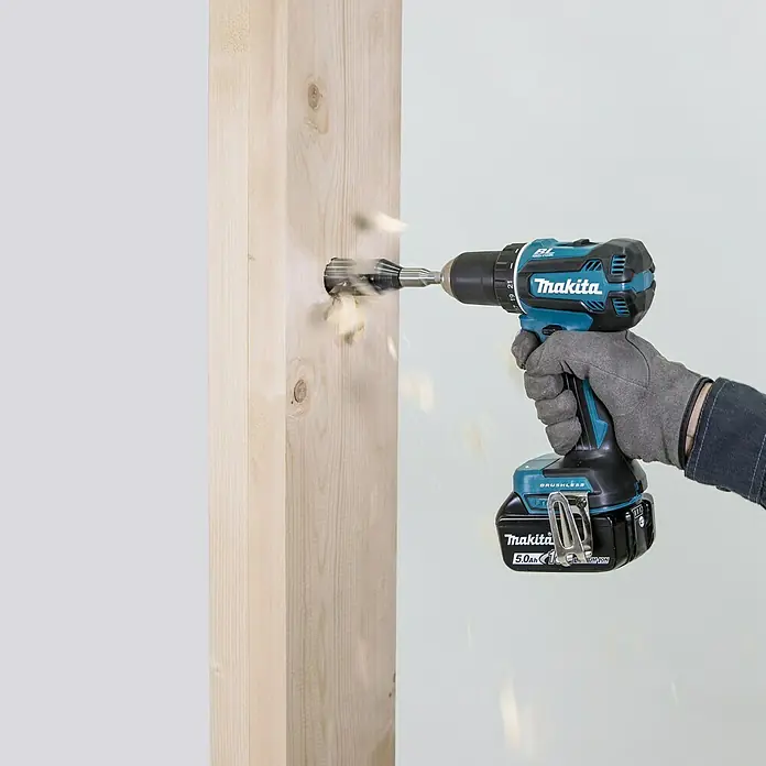Makita LXT 18V Akku-Bohrschrauber DDF485Z + Artikelnr. 33855482 hinzufügen* - 18 V, Ohne Akku, 5 Ah, 50 Nm - Nahaufnahme einer Makita Akku-Bohrmaschine, die in ein Holzstück bohrt und Späne erzeugt.
