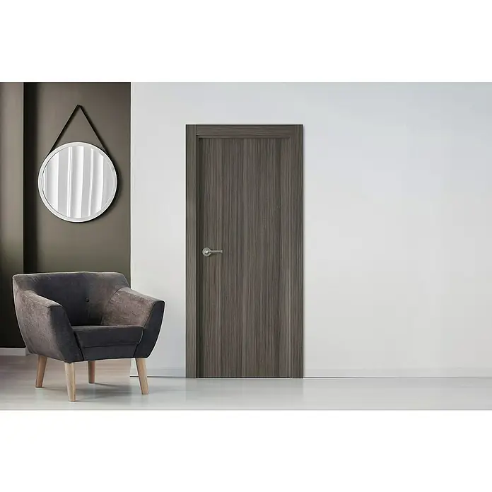 Pack puerta de interior vinílica Boston - 62,5 x 203 cm, Derecha - Elegante puerta de madera gris con manija en un interior moderno. El diseño complementa el sillón y el espejo.