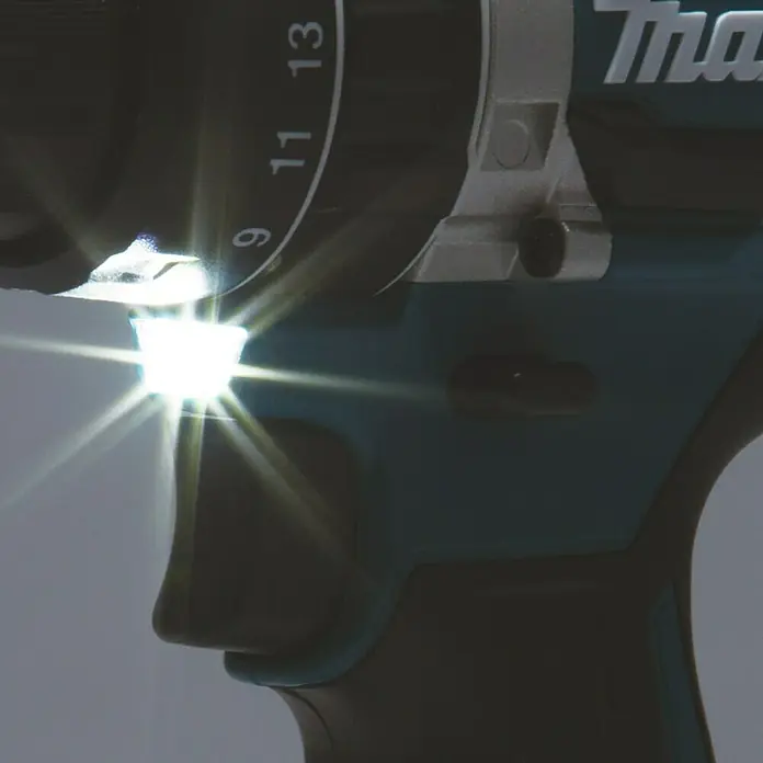 Makita LXT 18V Akku-Schlagbohrschrauber DHP484RTJ + Artikelnr. 33855482 hinzufügen* - 18 V, 2 Akkus, 54 Nm, Max. Schlagzahl: 30.000 /min - Nahaufnahme eines Makita Akku-Bohrers mit fokussiertem Lichtstrahl, der die Marke und das Design hervorhebt.