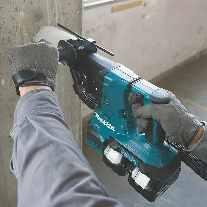 Makita LXT 18V Akku-Kombihammer DHR281ZJ - 36 V, Ohne Akku, 2,8 J - Eine Person bohrt mit einem türkisfarbenen Makita 36V Akku-Bohrhammer und Staubabsaugung in eine Betonwand.