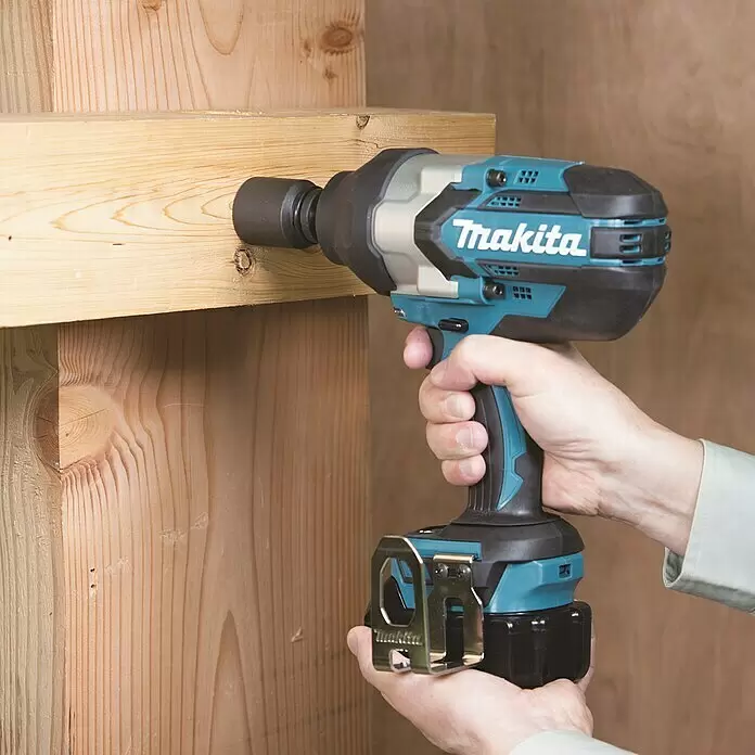 Makita LXT 18V Akku-Schlagschrauber DTW1002Z - 18 V, Ohne Akku - Eine Person verwendet einen türkis-schwarzen Makita Schlagschrauber, um einen großen Bolzen in einen Holzbalken zu schrauben.