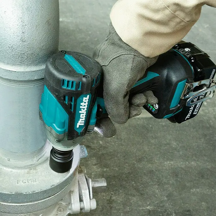 Makita LXT 18V Akku-Schlagschrauber DTW300Z + Artikelnr. 33855482 hinzufügen* - 18 V, Ohne Akku, 330 Nm, Max. Schlagzahl: 4.000 /min - Ein Makita Akku-Schlagschrauber wird an einem Rohr verwendet. Das Werkzeug ist in den Farben Schwarz und Türkis gehalten.
