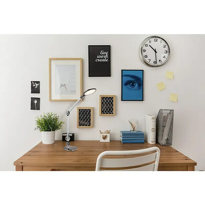 Globo LED-Tischleuchte - 9 W, L x B x H: 22,5 x 7,5 x 57,5 cm, Schwarz, Kaltweiß - Der Schreibtisch mit einer modernen Lampe, umgeben von Dekorationen wie Bilderrahmen, Pflanzen und Büroartikeln.