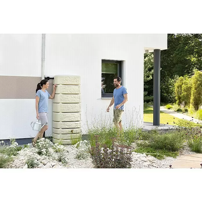 4rain Regenspeicher Slim Stone - 500 l, Beige - Beiger Regenwassertank, neben einem Fallrohr des Hauses zur Gartenbewässerung installiert.