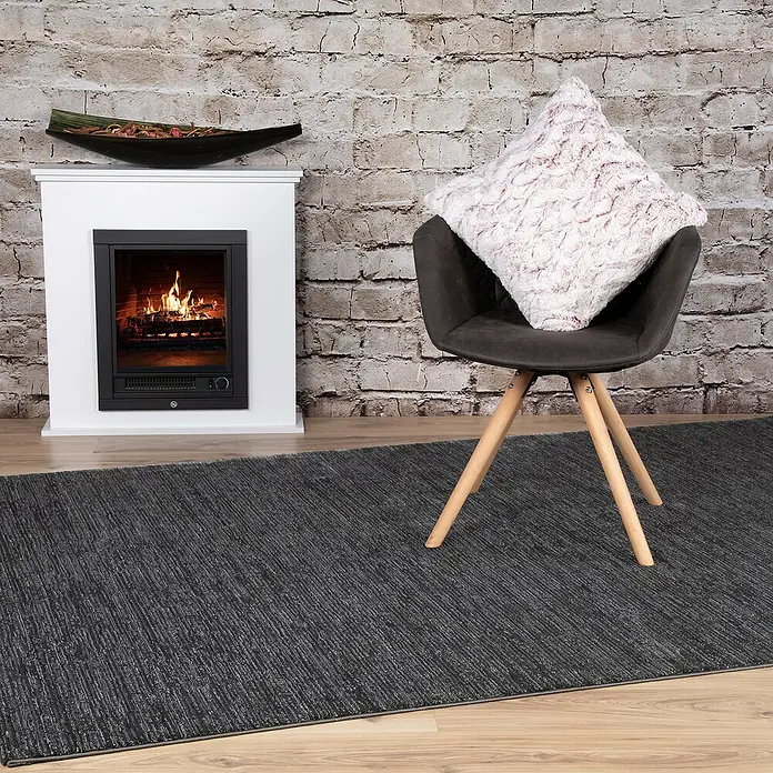 Kissen Smooth - Rot, 45 x 45 cm, 100 % Polyester - Elegantes Interieur mit modernem Kamin, stilvollem Stuhl und einem dunklen Teppich, der dem Raum Wärme verleiht.