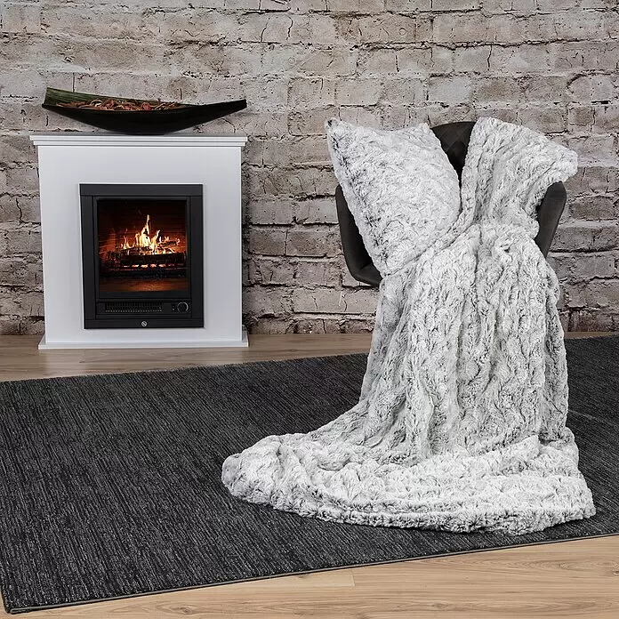 Kissen Smooth - Schwarz, 45 x 45 cm, 100 % Polyester - Weiß-graue Kunstfelldecke mit passendem Kissen auf einem Stuhl in einem gemütlichen Wohnzimmer.