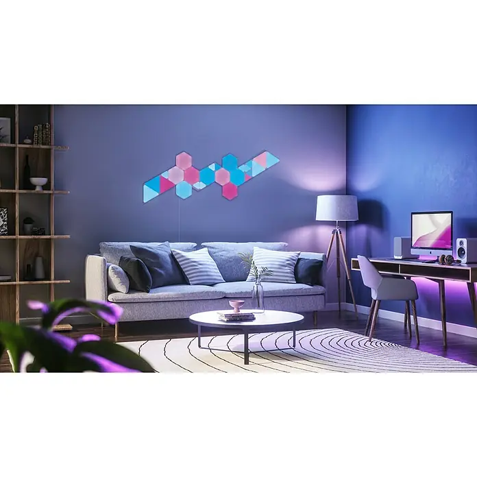 Nanoleaf Erweiterungskit Shapes Hexagons 3 Panels3 Stk., Weiß, RGBW, Hexagons, Smart Home-fähig: Ja - Ein stilvolles Wohnzimmer mit einem auffälligen Nanoleaf Light Panels Design an der Wand. Es erhellt den Raum in bunten Farben.