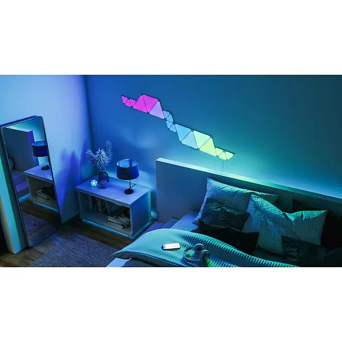 Nanoleaf Erweiterungskit Shapes Hexagons 3 Panels - 3 Stk., Weiß, RGBW, Hexagons, Smart Home-fähig: Ja - Eine Nahaufnahme eines Schlafzimmers mit den dreieckigen Nanoleaf-Lichtern an der Wand.