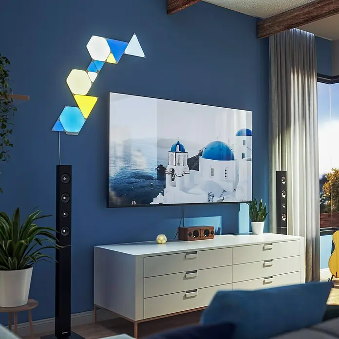 Nanoleaf Erweiterungskit Shapes Hexagons 3 Panels3 Stk., Weiß, RGBW, Hexagons, Smart Home-fähig: Ja - Ein modernes Wohnzimmer mit einem Fernseher, einer Kommode und einer Nanoleaf Light Panels Installation an der Wand.