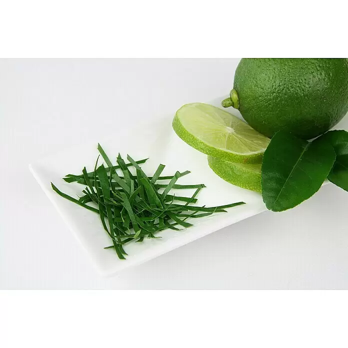 Blu Bio Kaffir-Limettenbaum - Citrus hystrix, Weiß, Topfgröße: 12 cm - Frische ganze Limette, Limettenscheiben und juliennierte Limettenblätter/schalen auf einem Teller.