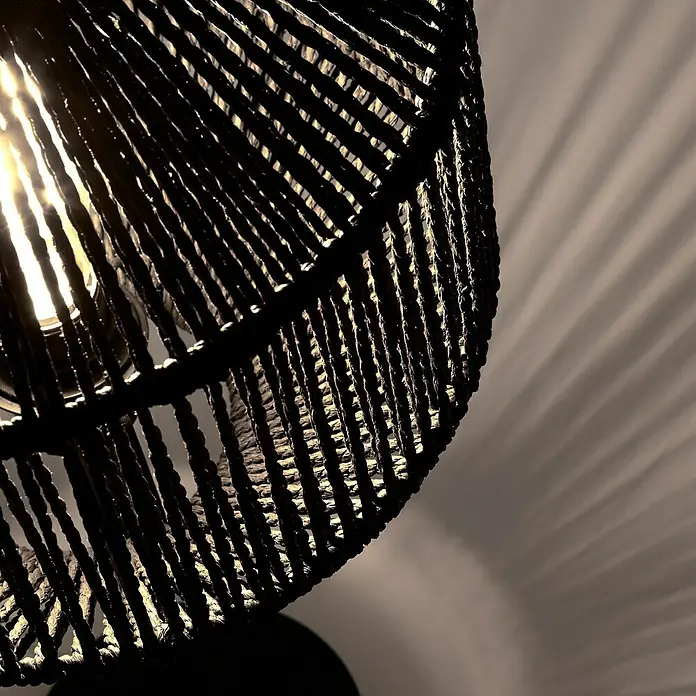 Searchlight Deko-Tischleuchte - L x B x H: 30,5 x 30,5 x 35 cm, Schwarz, E27 - Nahaufnahme einer Korblampe mit glühender Birne, die ein schattiges Muster an die Wand wirft.