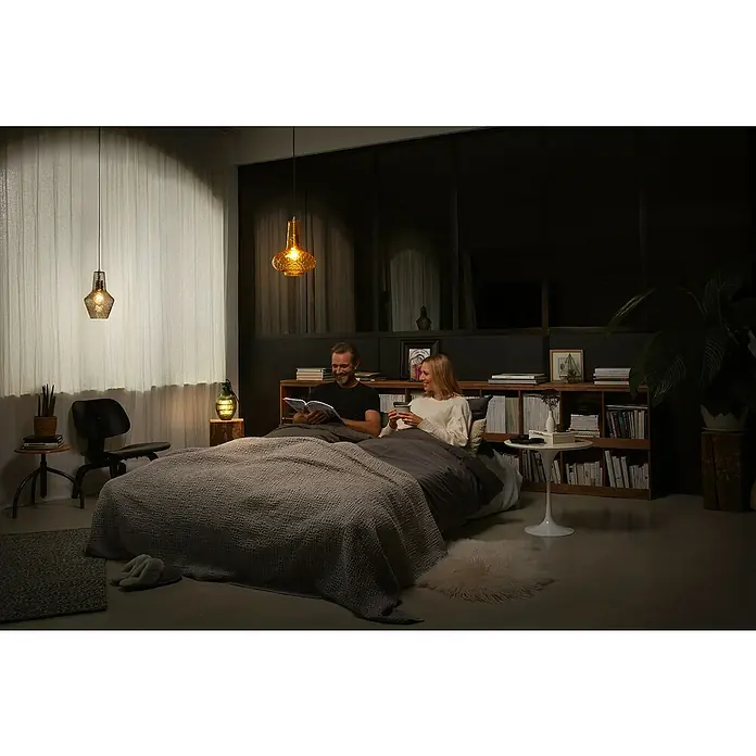 Ledvance Pendelleuchte rund 1906 Carve Pear - Orange, E27 - Stilvolles Schlafzimmer mit zwei dekorativen Pendelleuchten, die ein warmes Licht verbreiten und eine gemütliche Atmosphäre für die Lesenden schaffen.