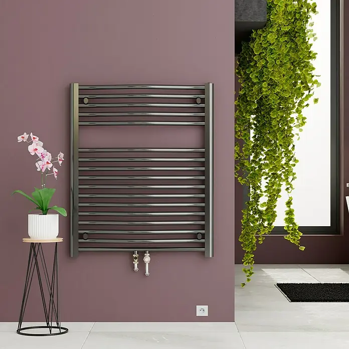 Admiral Badheizkörper Madrid - B x H: 600 x 770 mm, Wärmeleistung bei Vorlauftemperatur von 75 °C (D: 50): 484 W, Chrom - Bild eines modernen Handtuchwärmers an einer Wand im Badezimmer, umgeben von Pflanzen und einem kleinen Tisch mit einer Orchidee.
