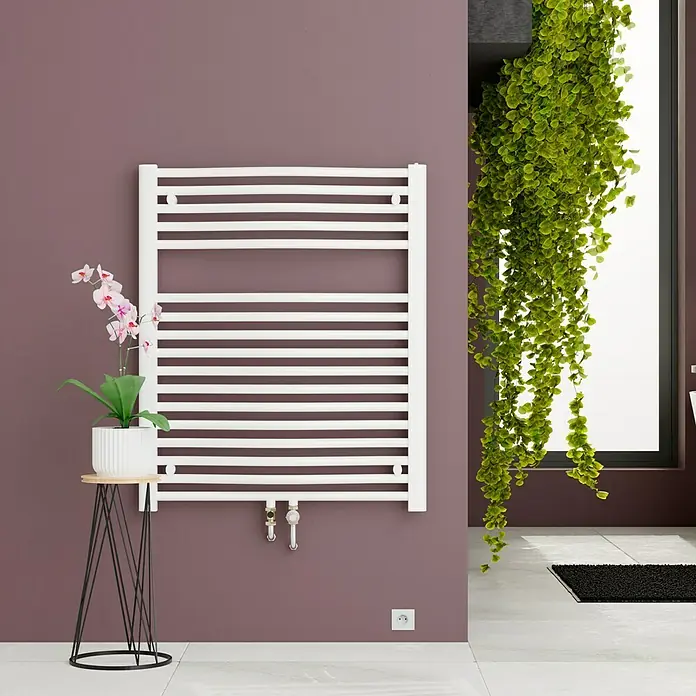 Admiral Badheizkörper Madrid - B x H: 600 x 770 mm, Wärmeleistung bei Vorlauftemperatur von 75 °C (D: 50): 484 W, Weiß - Ein weißer Handtuchwärmer hängt an einer lila Wand, dekoriert mit einer Orchidee auf einem Beistelltisch.
