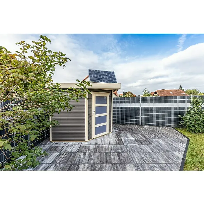 Offgridtec Solarmodul 0% MwSt. (gem. § 12 Abs. 3 UStG) - Nennleistung: 150 W, 114 x 68 x 3,5 cm, 1 Stk. - Das Bild zeigt einen grauen Geräteschuppen mit einer Solaranlage auf dem Dach und einer teilweise geöffneten Tür auf einer Terrasse.