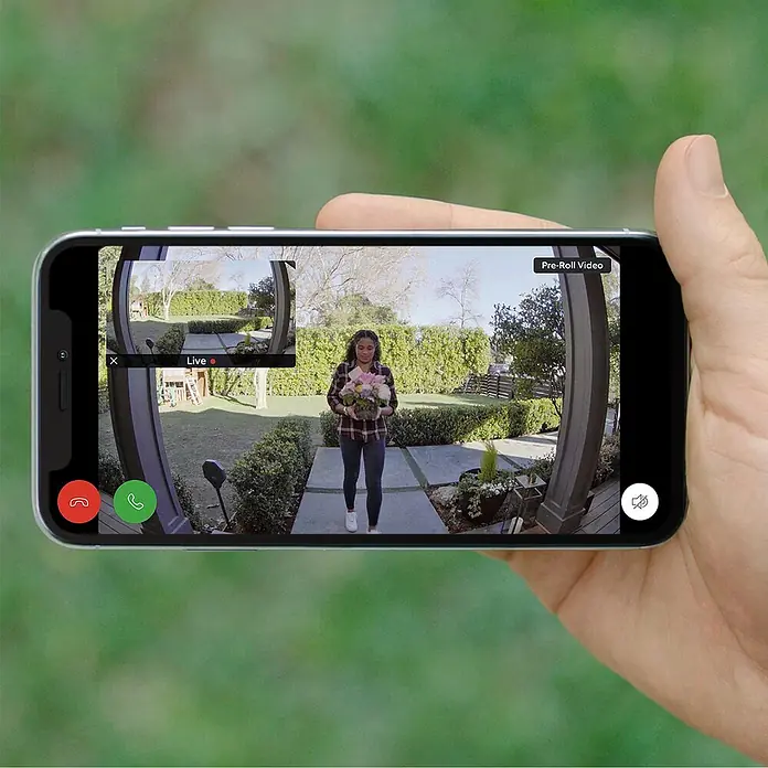 Ring Timbre con cámara Video Doorbell - Bronce - Una persona sostiene un smartphone que muestra un video del timbre Ring, mostrando a una mujer con flores.